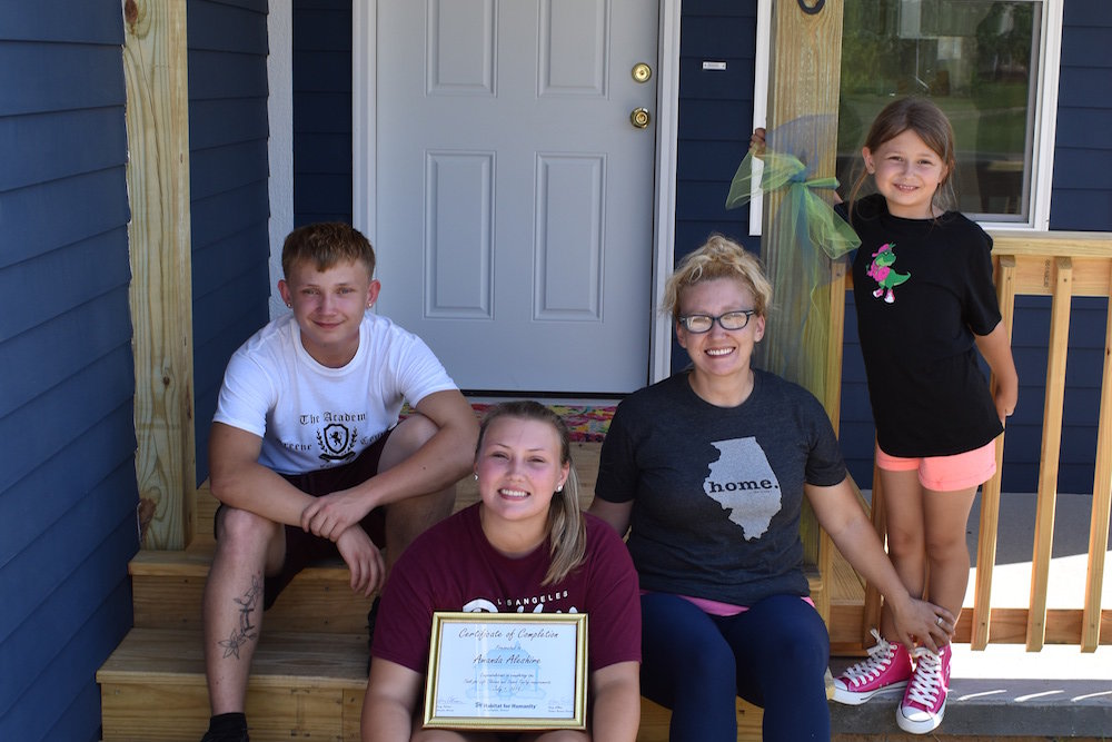 The new homeowner and her children pose outside the Habitat for Humanity home.